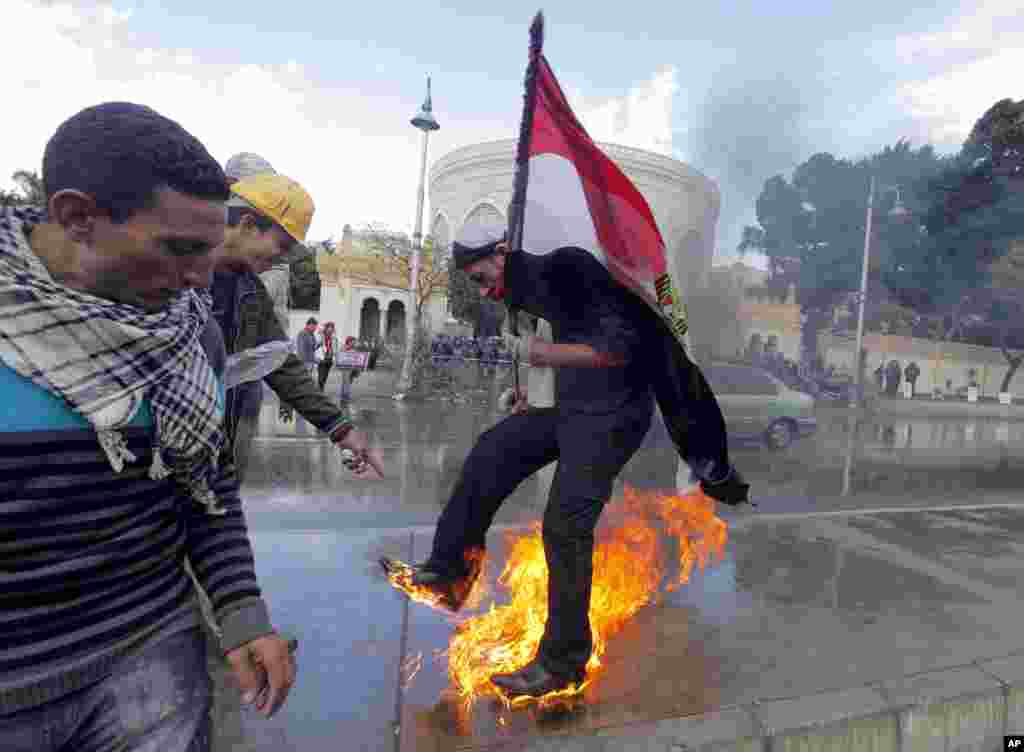 An Egyptian protester tries to escape from fire after he burned an anti-Morsi banner in front of the presidential palace in Cairo, Egypt, Feb. 1, 2013.