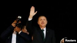 PM Turki Tayyip Erdogan (tengah) melambaikan tangan ke arah para pendukungnya, setibanya di bandara Ataturk di Istanbul (7/6). Demo anti-pemerintah Turki memasuki hari ke-10, dan PM Erdogan dalam orasinya menegaskan ia tidak berniat mundur menghadapi aksi demo tersebut.