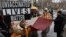 FILE - A person holds a sign during an anti-vaccine mandate protest ahead of the possible termination of New York City employees due to their vaccination status, in New York City, Feb. 7, 2022.