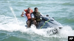 FILE - German national soccer player Lukas Podolski rides on a jet ski in Santo Andre near Porto Seguro, Brazil, June 10, 2014. 