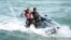 FILE - German national soccer player Lukas Podolski rides on a jet ski in Santo Andre near Porto Seguro, Brazil, June 10, 2014. 