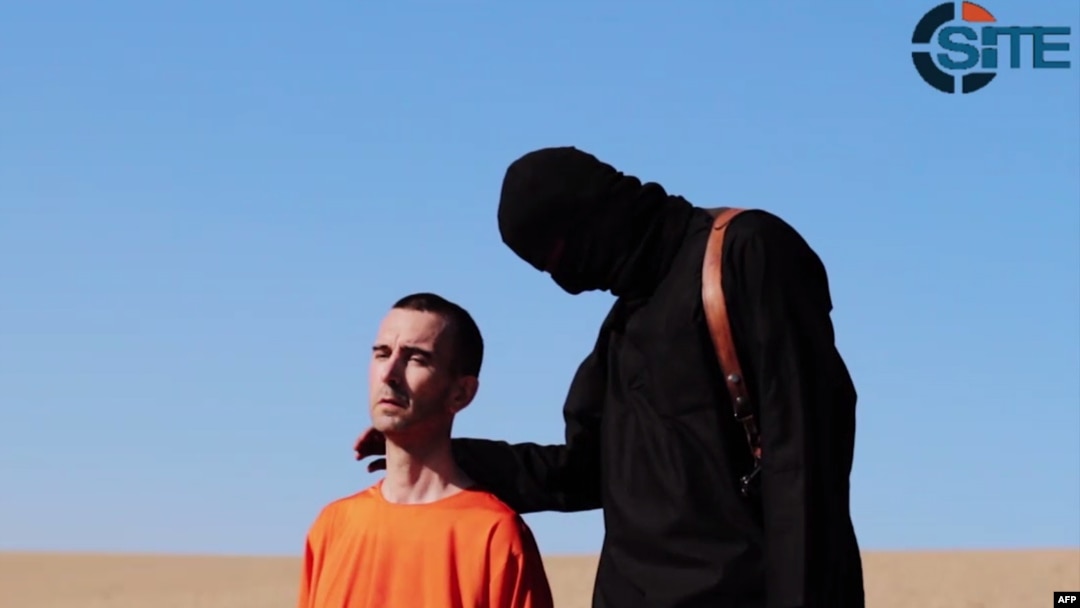 Seorang militan ISIS bersama pekerja bantuan Inggris David Haines (kiri) sebelum ia dibunuh di sebuah lokasi di Suriah (foto: dok).