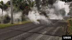 Steam rises from fissure 9 on Moku Street in the Leilani Estates Subdivision, Hawaii, May 7, 2018. HVO scientists on the scene reported hearing rumbling noises in the area.