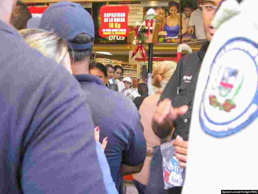 En algunos locales de Caracas la policía participa en la organización y entrega de números para poder ingresar al automercado.