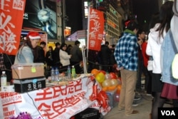 香港學生團體學民思潮平安夜設街站宣傳全民提名理念，並呼籲港人參與民陣元旦遊行爭普選(美國之音湯惠芸攝)