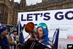 A pro-European demonstrator protests in front of a Leaver campaign board opposite the Houses of Parliament in London, Jan. 15, 2019, ahead of lawmakers' vote on whether to accept British Prime Minister Theresa May's Brexit deal. Later, the plan was soundly defeated. Britain is due to leave the EU on March 29.