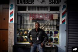 Philocles Julda, 44, poses for a photo in front of a Haitian barbershop in Tijuana, Mexico, Nov. 22, 2018. Julda is part of a group of Haitian immigrants who started the Association of the Defense of Haitian Migrants to give the community a place to help itself with everything from Spanish lessons to paying medical bills.