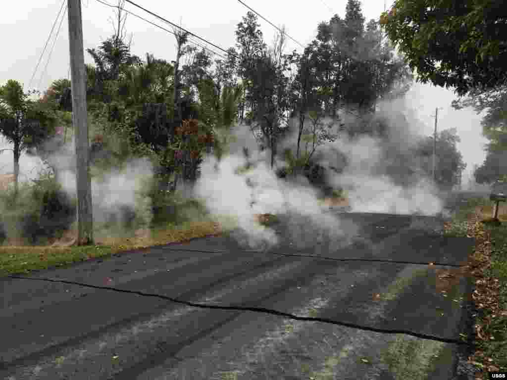 Steam rises from fissure 9 on Moku Street in the Leilani Estates Subdivision, Hawaii, May 7, 2018. HVO scientists on the scene reported hearing rumbling noises in the area.