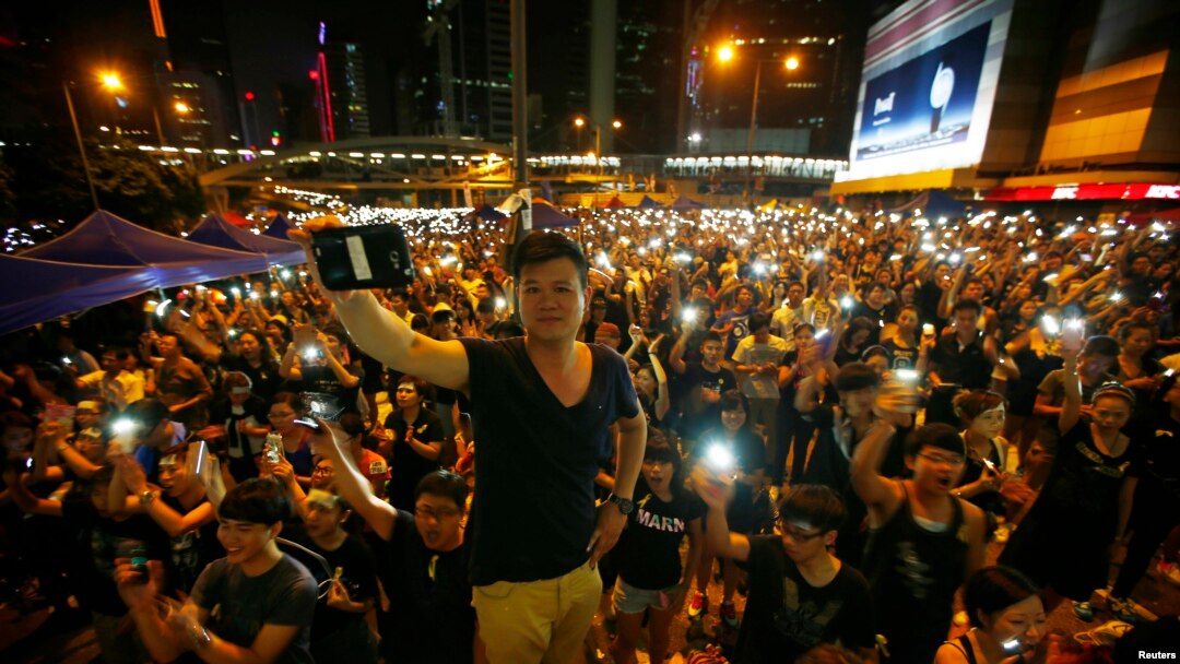 Demonstran menyalakan senter hp mereka ketika memblokir gedung-gedung pemerintah di Hong Kong 1 Oktober 2014. 