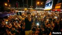 Demonstran menyalakan senter hp mereka ketika memblokir gedung-gedung pemerintah di Hong Kong 1 Oktober 2014. 