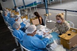 Health workers take residents' blood samples at a testing site for COVID-19 amid the new coronavirus pandemic in Rio de Janeiro, Brazil, July 17, 2020.