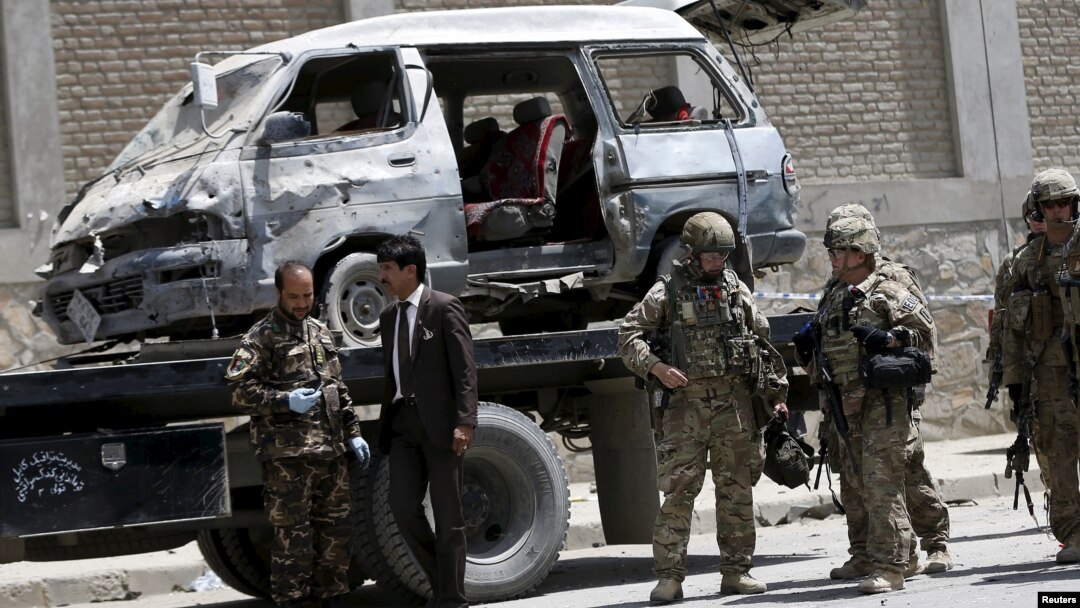 Afghan and foreign security forces keep watch at the site of car bomb attack in Kabul, May 17, 2015. 