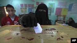 A woman casts her vote at a polling station during the second round of the parliamentary run-off election at Al Doki in Giza, on the outskirts of Cairo, Egypt, December 22, 2011.