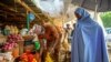 Une femme achète des tomates au marché de Yankaaba à Kano, au Nigeria, le 11 avril 2021.