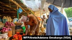 Une femme achète des tomates au marché de Yankaaba à Kano, au Nigeria, le 11 avril 2021.