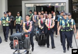North Korean taekwondo demonstration team members and other officials arrive at Gimpo International Airport in Seoul, South Korea, June 23, 2017.