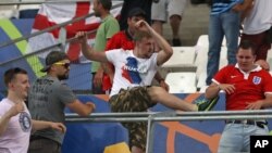 FILE - In this Saturday, June 11, 2016 file photo, Russian supporters attack an England fan at the end of the Euro 2016 Group B soccer match between England and Russia, at the Velodrome stadium in Marseille, France. 