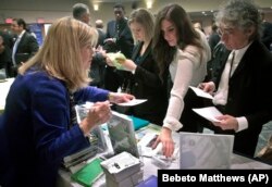 Patricia Mazza, left, meets job seekers, including recent college grads Ashley Deyo, 22, second from left, and Chyna Dama, 23, second from right, during a 2012 National Career Fairs' job search event in New York.