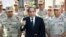 In this photo provided by MENA news agency, Egyptian President Abdel-Fattah el-Sissi speaks in front of the state-run TV ahead of a military funeral for troops killed in an assault in the Sinai Peninsula, as he stands with army commanders in Cairo, Oct. 25, 2014.