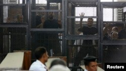 Muslim Brotherhood's General Guide Mohamed Badie (R) is pictured in a defendant's cage with other defendants in a courtroom in Cairo, June 7, 2014. 