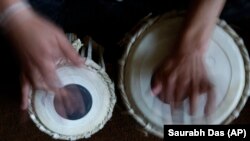 Seorang siswa belajar memainkan tabla di Institut Musik Nasional Afghanistan sebagai ilustrasi. Empat musisi Afganistan, yang kini bermain dan belajar di National Conservatory, tampil bersama beberapa rekan Portugis mereka. (Foto: AP)