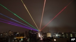 FILE - The Global Rainbow, an outdoor laser projection created by New York artist Yvette Mattern, is projected into the night sky to mark the Gay Pride Parade, which was cancelled due to the coronavirus pandemic, in Sao Paulo, Brazil, June 14, 2020.