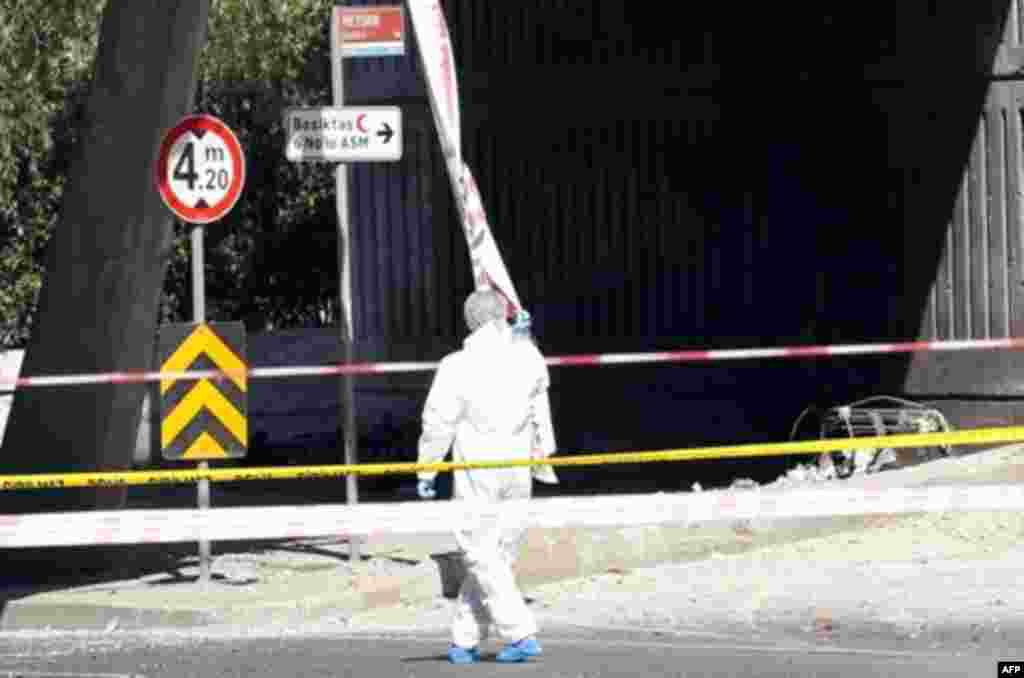 A police forensic officer inspects a blast scene with the remains of an exploded bicycle in the background, in Istanbul May 26, 2011. A bicycle bomb wounded seven people including a police officer in Istanbul on Thursday, Istanbul's police chief Huseyin C