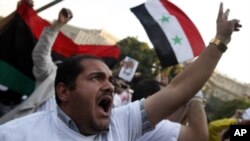 Protesters chant slogans during an anti-Syrian regime protest in front of the Arab League headquarters in Cairo, Sunday, Oct. 16, 2011.