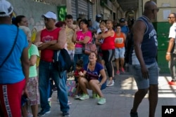 People wait in line to buy chicken at a government-run grocery store in Havana, Cuba, April 17, 2019.