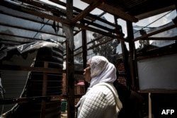 A woman looks at burned equipement in an Ebola treatment center, which was attacked early on March 9, 2019, in Butembo, Democratic Republic of the Congo.