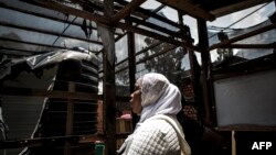 wata mata na kallon wani sashi da mahara suka kona a wata cibiyar kula da masu cutar Ebola a Congo a Butembo,