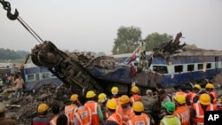 Rescuers search through debris after 14 cars of an overnight passenger train rolled off the track near Pukhrayan village Kanpur Dehat district, Uttar Pradesh state, India, Nov. 20, 2016.