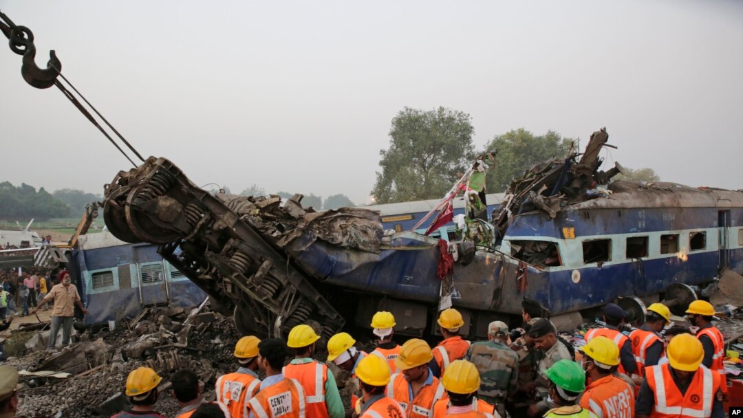 Tim SAR melakukan pencarian korban di antara reruntuhan gerbong kereta yang hancur akibat keluar dari jalur rel di dekat desa Pukhrayan distrik Kanpur Dehat, negara bagian Uttar Pradesh, India, 20 November 2016. (AP Photo/Rajesh Kumar Singh)