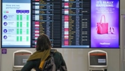 A passenger looks at a departures board at London Heathrow Airport's T3 as the US reopens its borders to UK visitors in a significant boost to the travel sector, in London, Monday, Nov. 8, 2021. (Anthony Upton/PA via AP)