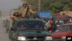 Pakistan army troops rush towards an air force base in Peshawar, Pakistan, Friday, Sept. 18, 2015. 