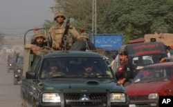 Pakistan army troops rush towards an air force base in Peshawar, Pakistan, Friday, Sept. 18, 2015.