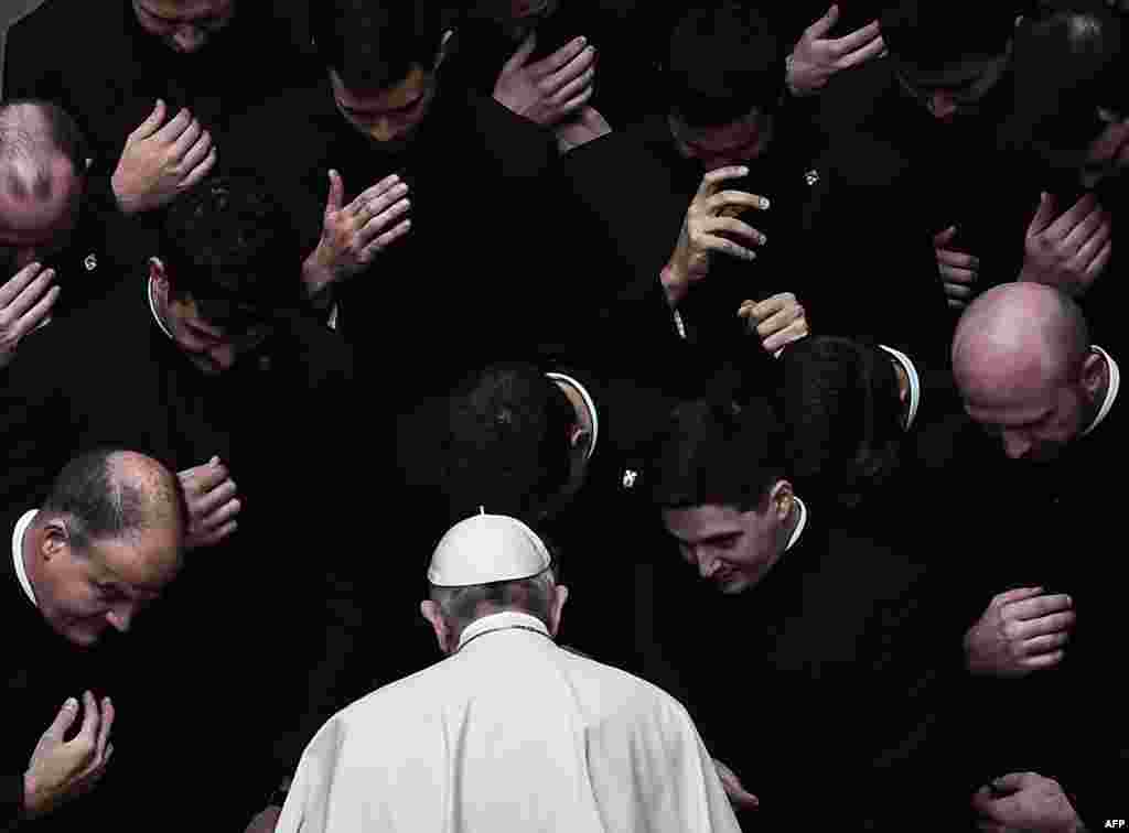 Pope Francis prays with priests at the end of a limited public audience at the San Damaso courtyard at the Vatican, Sept. 30, 2020.