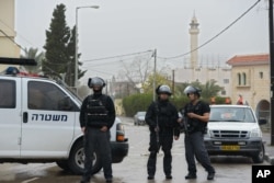 Israeli policemen stand on guard in the village of Arara, northern Israel, Jan. 8, 2016.