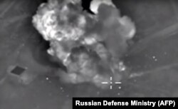 An image taken from video purports to show explosions after airstrikes carried out by Russia's air force on what it said was an Islamic State ammunition depot in the Syrian province of Idlib, Oct. 14, 2015..
