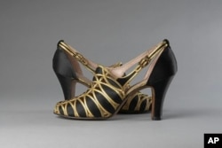 This image provided by the Museum of the City of New York shows black silk satin and gold-tone leather evening shoes made by Delman Black in 1936. (Museum of the City of New York via AP)