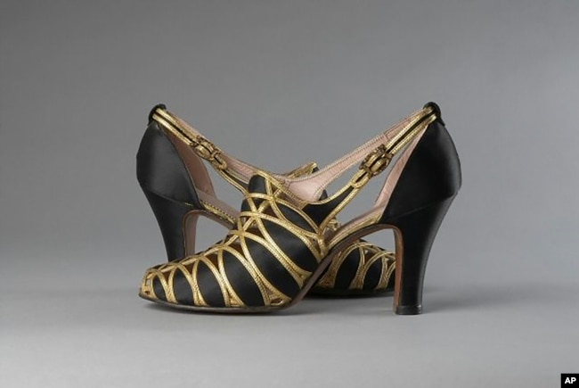 This image provided by the Museum of the City of New York shows black silk satin and gold-tone leather evening shoes made by Delman Black in 1936. (Museum of the City of New York via AP)