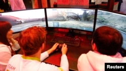 People play a video game on the stand of Acer at the IFA Electronics show in Berlin, Germany, Sept. 2, 2015. 