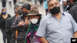 Ecuatorianos en Quito, la capital del país, llevan máscaras para protegerse del contagio del nuevo coronavirus, el 8 de diciembre de 2021.