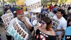 Демонстранты протестуют против закона штата Аризона о нелегальных иммигрантах. Финикс. 25 июня 2012 г.