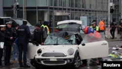 Agentes da polícia vasculham o carro do motorista que atropelou uma multidão em Munique, Alemanha, 13 fevereiro 2025