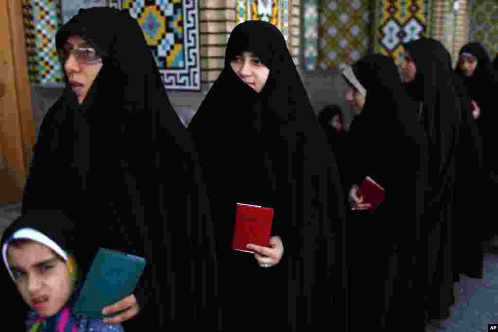 Iranian women wait in line at a polling station to vote during presidential elections in Qom, 125 kilometers (78 miles) south of the capital Tehran, Iran. 