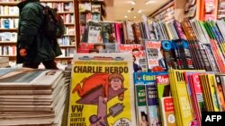 The first issues of the German version of French satirical weekly Charlie Hebdo are for sale at a newsstand in Berlin, Dec. 1, 2016. 