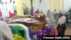 Recueillement devant les cercueils des victimes de l'attaque de l'église Fatima à Bangui, le 7 mai 2018. (VOA/Freeman Sipila)