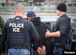 FILE - U.S. Immigration and Customs Enforcement officers detain a suspect as they conduct a targeted enforcement operation in Los Angeles, Feb. 7, 2017.