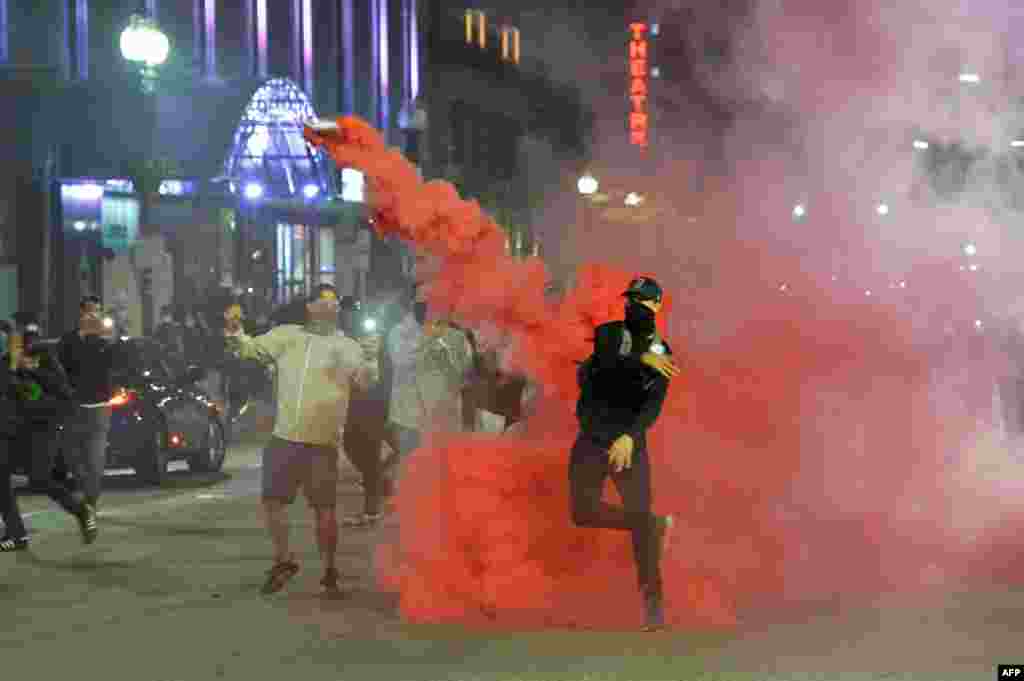 Protesters throw back smoke canisters during clashes with police during a demonstration over the death of George Floyd, an unarmed black man who died in Minneapolis Police custody, in Boston, Massachusetts on May 31, 2020.